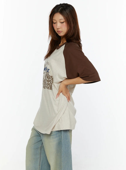 Graphic Oversided Tee CL515 Brown side view on model showing brown raglan sleeves beige body with star chaos order chest print and dropped shoulder