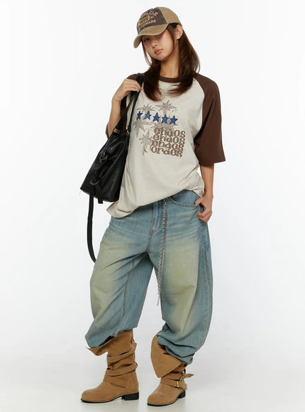 Graphic Oversided Tee CL515 Brown full-body styling shot on model with baseball cap black tote bag wide-leg jeans and tan boots street style look