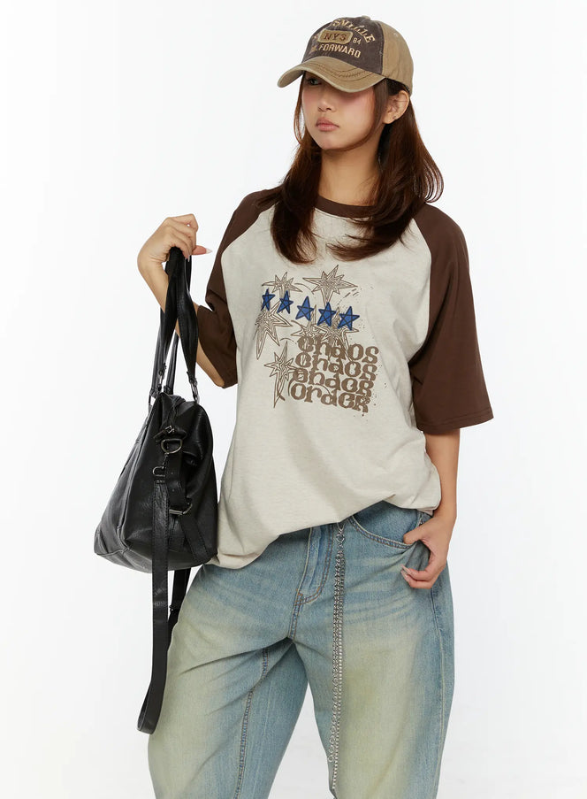LEWKIN Graphic Oversided Tee CL515 Brown front view on model wearing baseball cap and black bag styled with wide-leg jeans, star and chaos order print