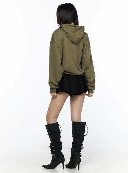 Graphic Oversized Hoodie CL524 Dark green back view on model showing clean plain back, oversized hood, dropped shoulders, styled with black mini skirt and buckle boots