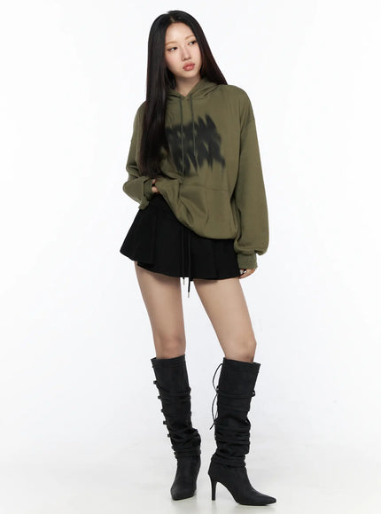 Graphic Oversized Hoodie CL524 Dark green full-body front view on model styled with black pleated mini skirt and tall black buckle boots