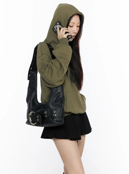 Graphic Oversized Hoodie CL524 Dark green lifestyle side shot on model with hood up, talking on phone, carrying black leather buckle bag, black mini skirt