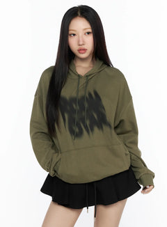 LEWKIN Graphic Oversized Hoodie CL524 Dark green front view on model wearing black mini skirt, blurred black graphic print on chest, drawstring hood