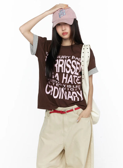 LEWKIN Graphic Oversized Layered Tee CL524 Brown front shot on model with pink cap and cream bag, pink letter print, gray cuffed sleeves, M/L