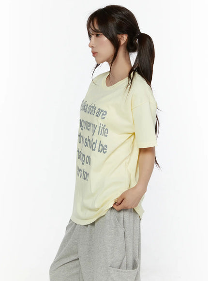 Graphic Oversized Tee CL508 Yellow side view on model with ponytail, showing relaxed oversized silhouette and gray letter graphic print
