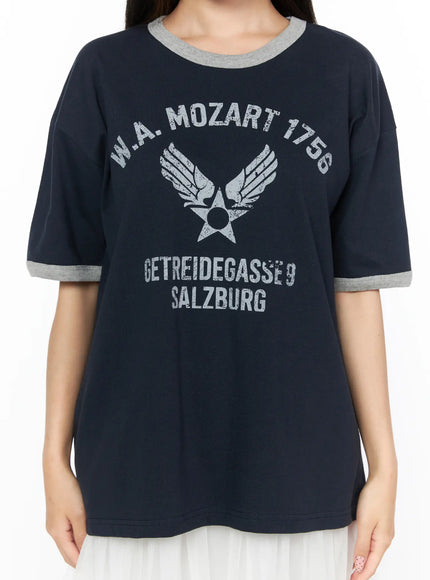 Graphic Oversized Tee CL517 Dark blue close-up front detail on model, W.A. Mozart 1756 winged star distressed graphic print, gray contrast ringer neckline