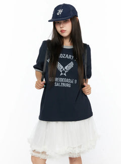 LEWKIN Graphic Oversized Tee CL517 Dark blue front view on model wearing cap and backpack, styled with white tulle skirt, vintage Mozart graphic print