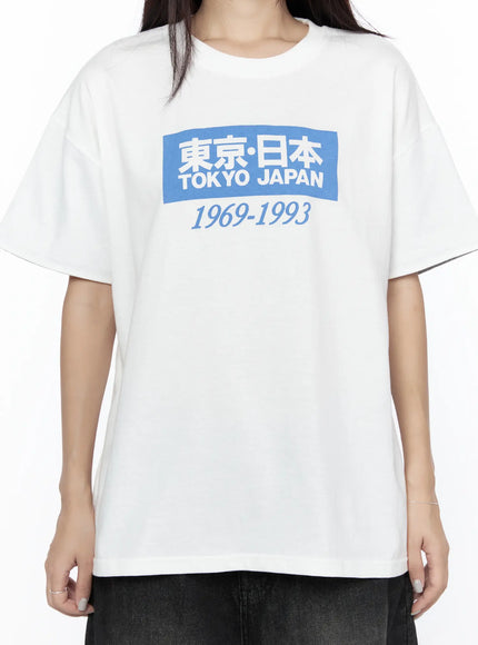Graphic Oversized Tee CL527 White close-up front on model without sleeve cuffs showing full blue Tokyo Japan 1969-1993 graphic print on oversized cotton tee