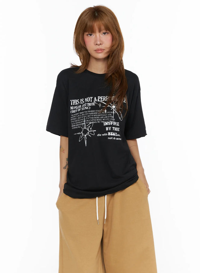 Graphic Oversized Top CL503 Black front shot on model standing facing forward with grunge star graphic print styled with tan drawstring pants