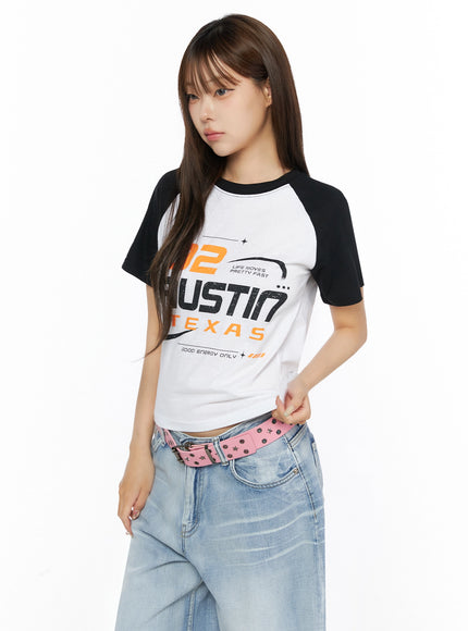 Graphic Print Color Block Tee IL523 White side-front shot on model with black raglan sleeves, Austin Texas graphic print, styled with pink belt and jeans