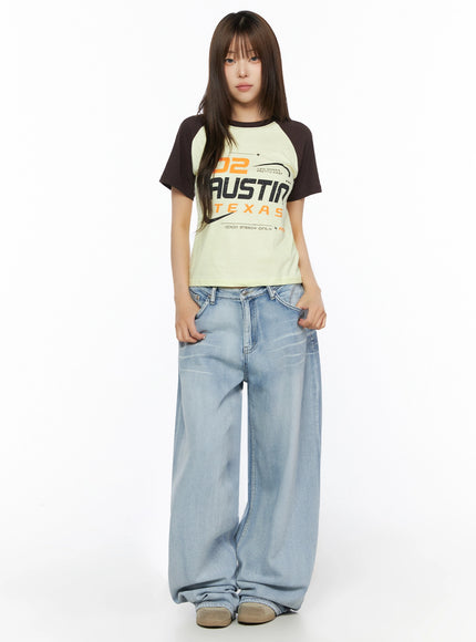 Graphic Print Color Block Tee IL523 Yellow full-body front shot on model standing straight, dark brown raglan sleeves, paired with wide-leg light wash jeans