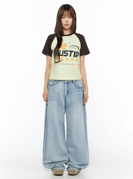 Graphic Print Color Block Tee IL523 Yellow full-body front shot on model standing with arms relaxed, dark brown raglan sleeves, cropped length, wide-leg denim styling