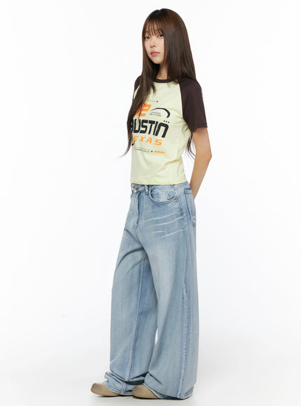 Graphic Print Color Block Tee IL523 Yellow side shot on model with hand in pocket, dark brown raglan sleeves, cropped fit, styled with wide-leg denim