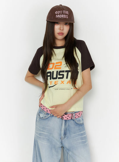 LEWKIN Graphic Print Color Block Tee IL523 Yellow front shot on model wearing brown cap, pink star belt, wide-leg jeans, hands clasped