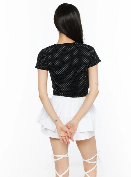 Graphic Print Crop Tee CU530 Black back view on model standing straight showing all-over white polka dot pattern short sleeves and cropped silhouette
