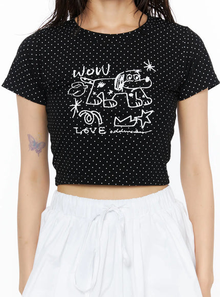 Graphic Print Crop Tee CU530 Black close-up front detail on model torso showing white graffiti WOW LOVE print on black polka dot ribbed fabric