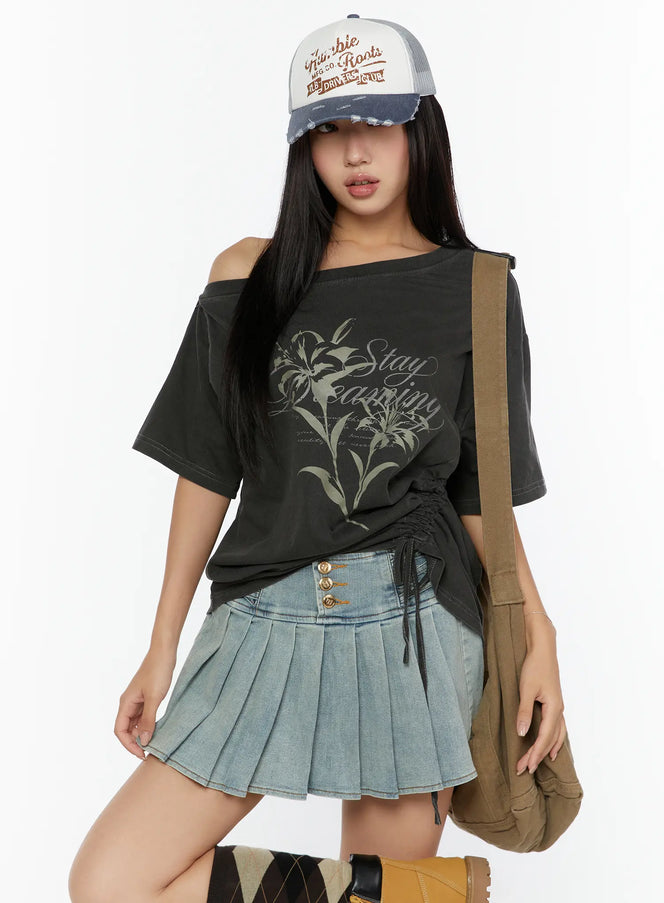 LEWKIN Graphic Print One-Shoulder Oversized Tee CU529 Dark gray M/L front model shot with cap and crossbody bag, lily print, side ruched drawstring hem