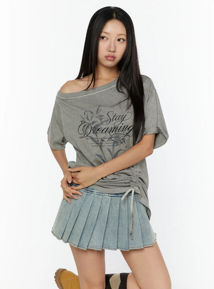 Graphic Print One-Shoulder Oversized Tee CU529 gray front model shot hands clasped, lily Stay Dreaming script print, asymmetric off-shoulder neckline, ruched hem