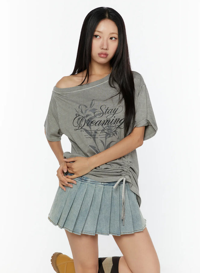Graphic Print One-Shoulder Oversized Tee CU529 gray front model shot hands clasped, lily Stay Dreaming script print, asymmetric off-shoulder neckline, ruched hem