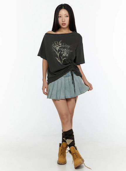 Graphic Print One-Shoulder Oversized Tee CU529 dark gray full-body front model shot styled with denim pleated mini skirt and tan boots, side ruched drawstring detail
