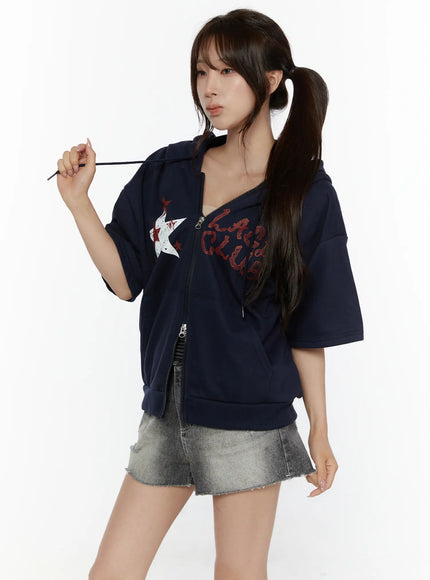 Graphic Print Short Sleeve Hooded Zip-Up CL507 Navy front three-quarter view on model pulling hood drawstring open zip styled with denim shorts red star print