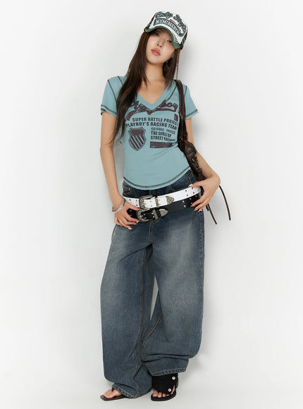 Graphic Print V-Neck Tee IL523 Light blue full-body front model shot styled with cap dual belts leather bag and wide-leg jeans