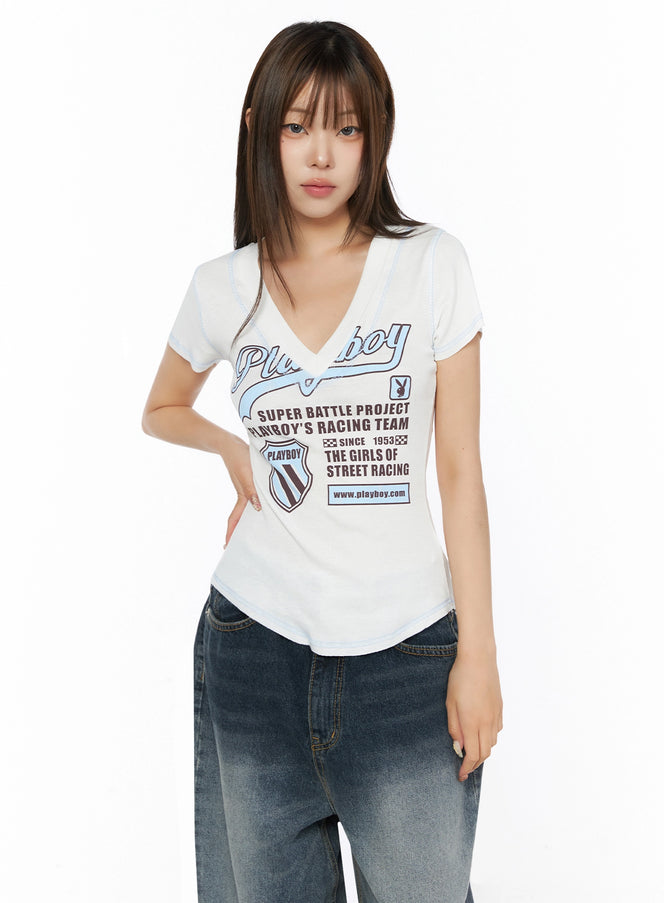 Graphic Print V-Neck Tee IL523 White front model shot with V-neck and Playboy racing graphic print paired with wide-leg jeans