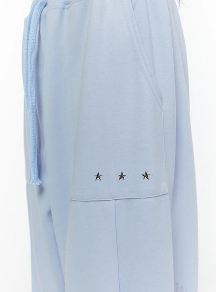 Graphic Print Wide Sweatpants CL507 light blue close-up detail of waistband drawstring elastic and three silver metal star studs on side pocket