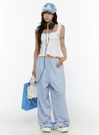 LEWKIN Graphic Print Wide Sweatpants CL507 light blue front shot on model standing with hand on hip styled with white crop top and cap