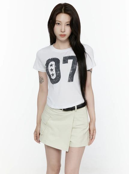 Graphic Retro Print T-Shirt IL522 White front view on model showing distressed black 07 star numeral graphic on white cotton crop tee with cream cargo skort