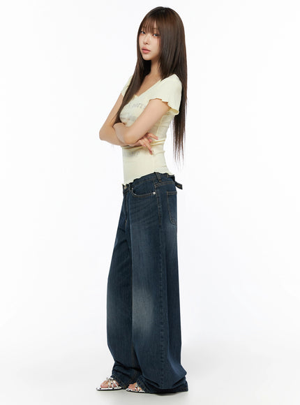 Graphic Scoop Neck Top IL523 Yellow full-length side shot on model with arms crossed, showing slim silhouette and lettuce hem against wide-leg jeans