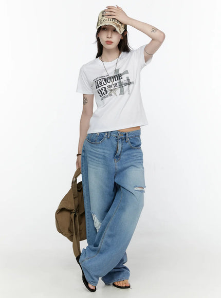LEWKIN Graphic Semi-Crop T-Shirt IL522 White front full-body shot on model wearing cap, styled with ripped wide-leg jeans and canvas tote bag