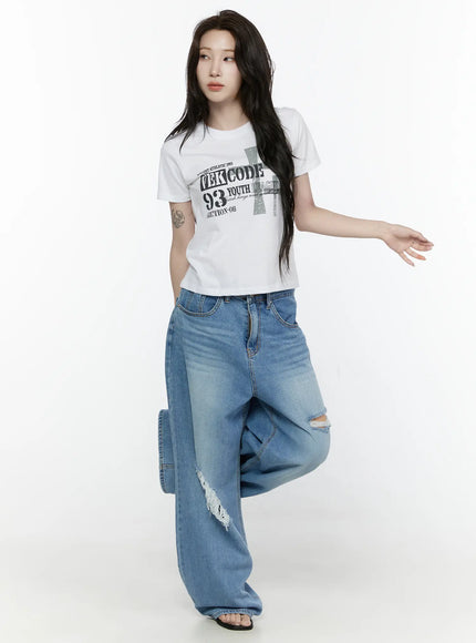 Graphic Semi-Crop T-Shirt IL522 White three-quarter front shot on model with leg raised, styled with ripped wide-leg jeans and accessory necklace