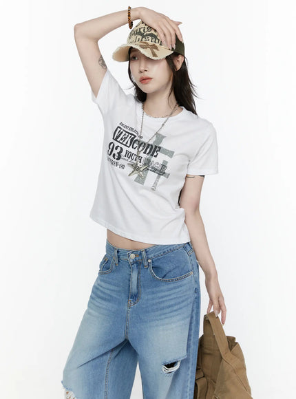 Graphic Semi-Crop T-Shirt IL522 White upper-body front shot on model wearing cap, showing cropped hem and graphic print with chain necklace styling