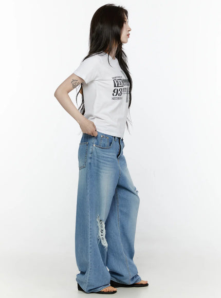 Graphic Semi-Crop T-Shirt IL522 White side shot on model showing cropped silhouette, fitted cotton fabric, and short sleeve length paired with wide-leg jeans
