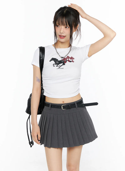 LEWKIN Graphic Shirred Crop Tee CU530 White S/M front view on model hand in hair styled with gray pleated mini skirt black belt and leather backpack