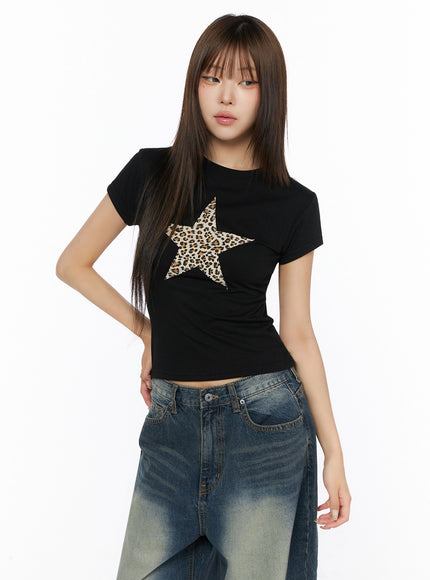 Graphic Short Sleeve T-Shirt IL523 Black front model shot wearing slim crop tee with leopard star applique graphic paired with wide-leg distressed jeans