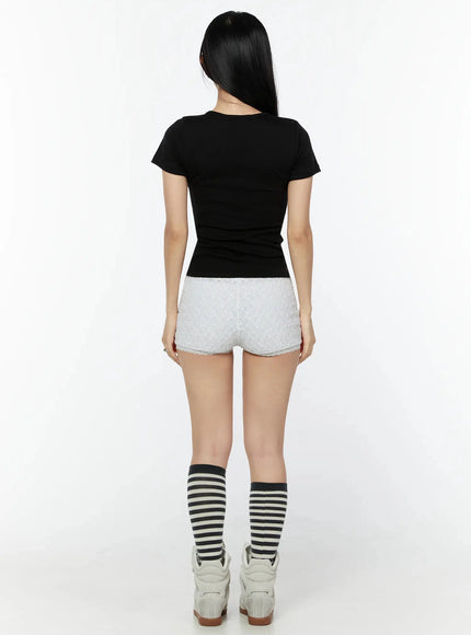 Graphic Short Sleeve Tee IU524 Black back model shot showing plain ribbed back and short sleeve cut, paired with white lace shorts and striped socks