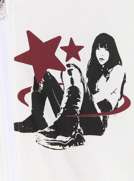 Graphic Short Sleeve Zip-Up Hoodie IU525 White close-up detail of right chest graphic, seated figure with red stars and swirl motif, zipper hardware visible on cotton fabric