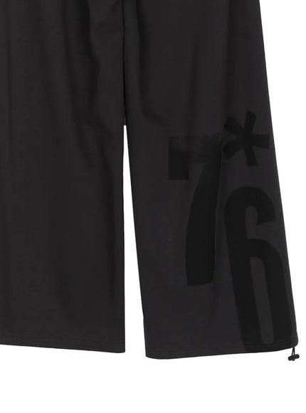 Graphic Sweatpants IL509 Black close-up detail of lower leg showing tone-on-tone black 7*6 brushstroke graphic print on smooth black fabric with drawstring hem