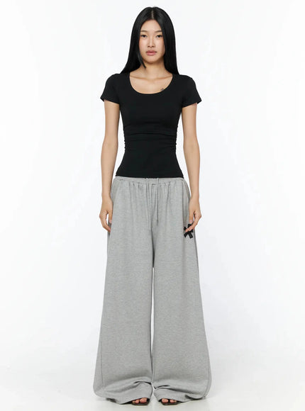 Graphic Sweatpants IL509 Gray full-length front model shot standing model in black tee with drawstring waistband asterisk print on thigh ultra-wide leg silhouette