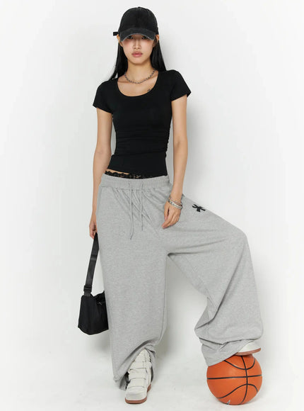 Graphic Sweatpants IL509 Gray front model shot model with cap shoulder bag and basketball prop lace waistband visible black tee styled streetwear look