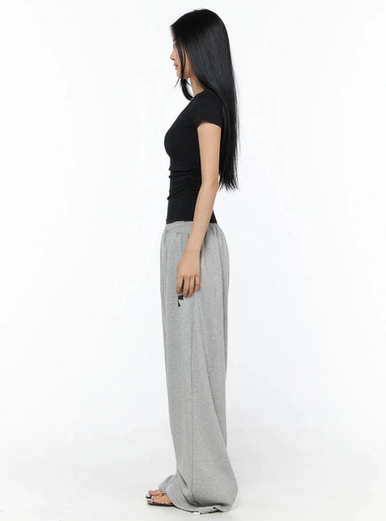 Graphic Sweatpants IL509 Gray side model shot full-length model in black scoop tee showing wide-leg drape side seam and small asterisk logo near pocket