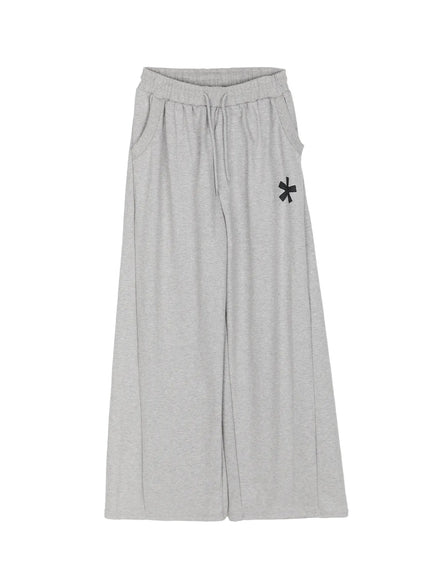 Graphic Sweatpants IL509 Gray flat-lay front view showing full wide-leg silhouette elastic drawstring waistband asterisk logo print and side pockets on white background