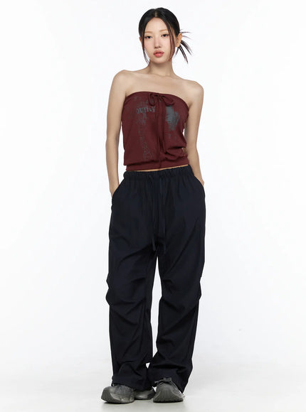 Graphic Tube Top CL527 Dark red full-body front model shot standing pose with graphic print tie detail paired with wide-leg black cargo pants and chunky sneakers