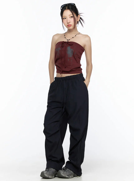 Graphic Tube Top CL527 Dark red full-body front model shot with sunglasses accessories necklace graphic print tube top paired with wide-leg black pants and sneakers