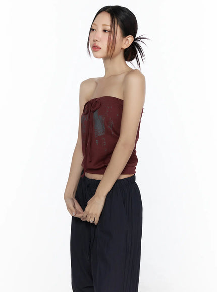 Graphic Tube Top CL527 Dark red side-angle close-up model shot highlighting center tie bow detail and distressed graphic print with black pants