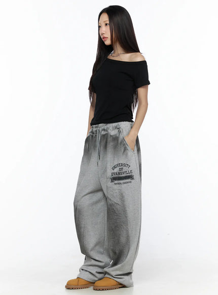 Graphic Wide Leg Sweatpants CL527 Gray side full-length shot on model in black off-shoulder top showing University of Evansville Physical Education print