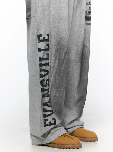 Graphic Wide Leg Sweatpants CL527 Gray close-up side shot showing vertical Evansville distressed letter print along left leg hem pooling over boots