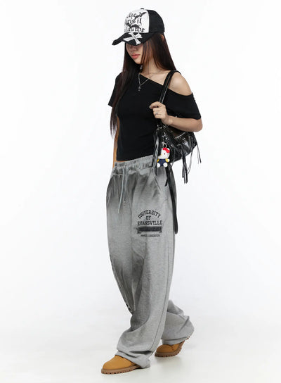 LEWKIN Graphic Wide Leg Sweatpants CL527 Gray M/L full-length side shot on model wearing cap and black crop top styled with tan boots